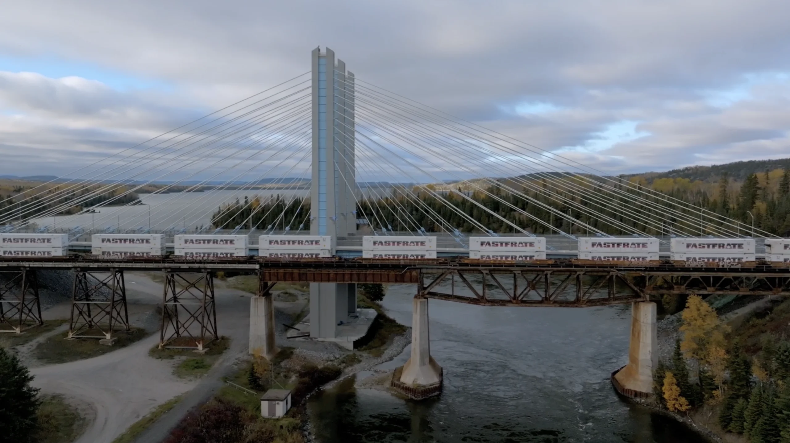 Freight train crossing a cable-stayed bridge over a river