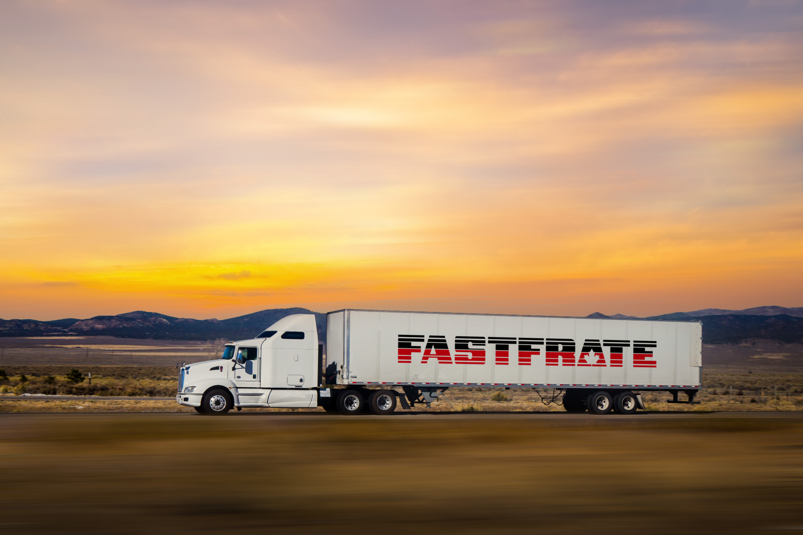 White truck with "FASTFRATE" logo driving against a sunset backdrop