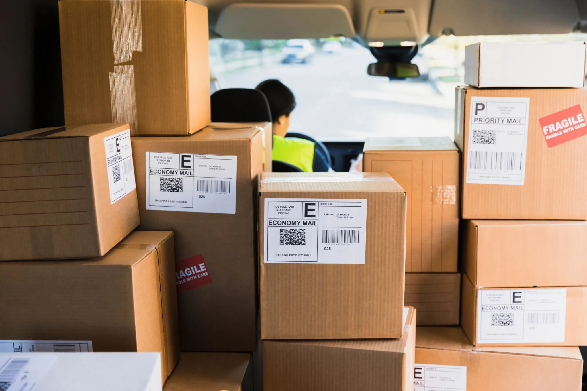 Packed delivery van filled with boxes and a driver in the front seat
