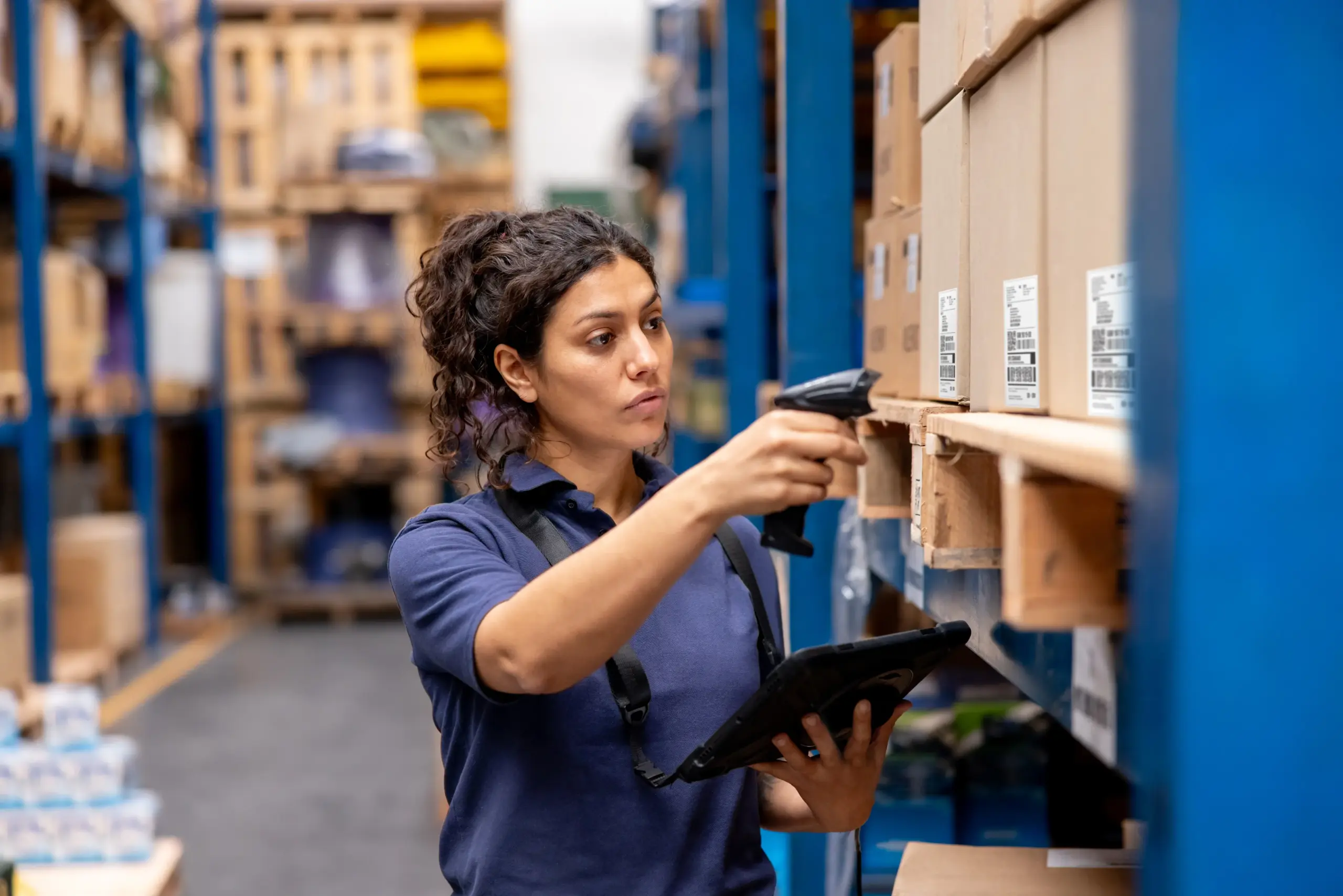 Warehouse worker scanning boxes with a handheld device and tablet