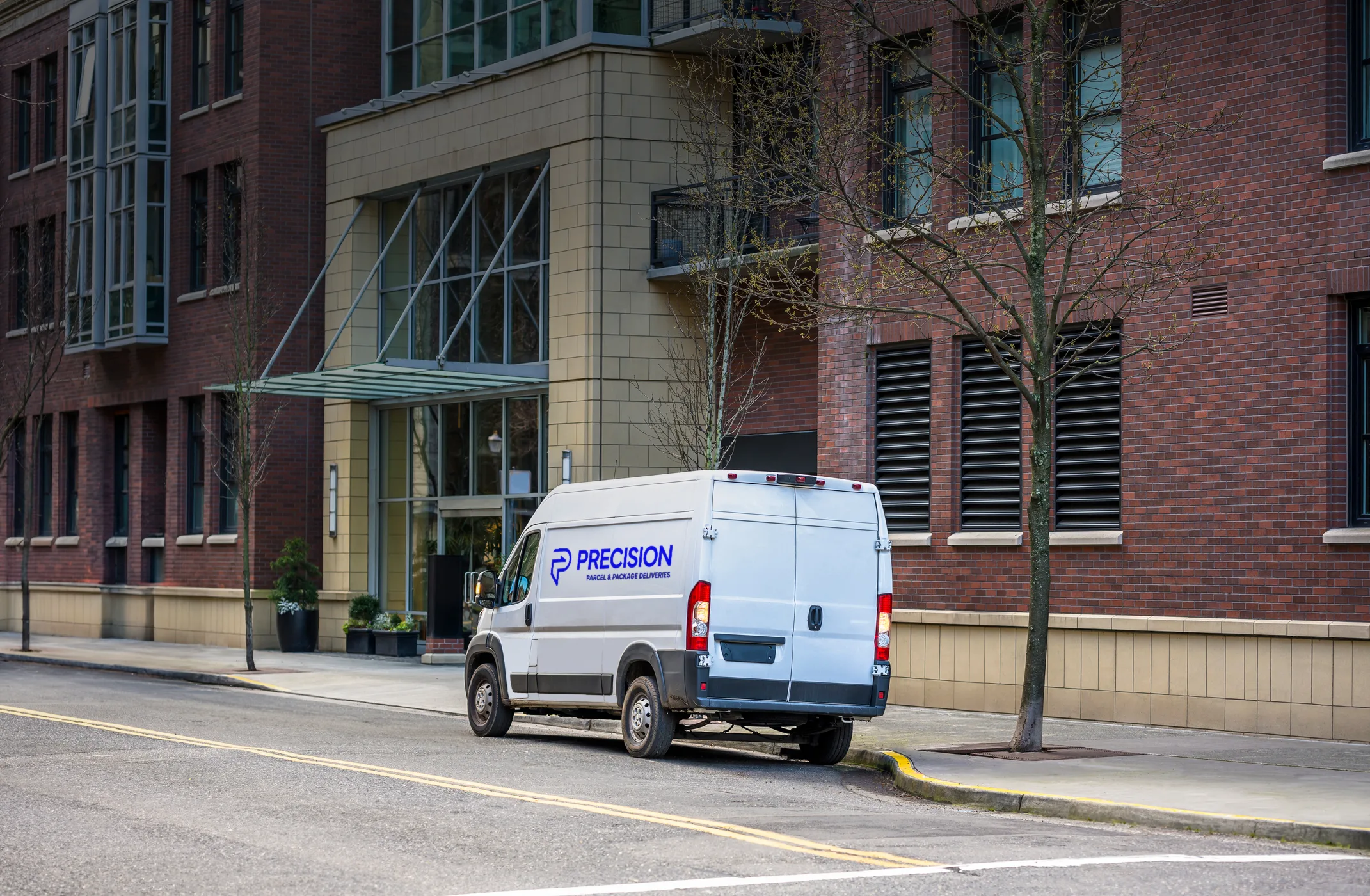 Delivery van parked on the street in front of a modern building