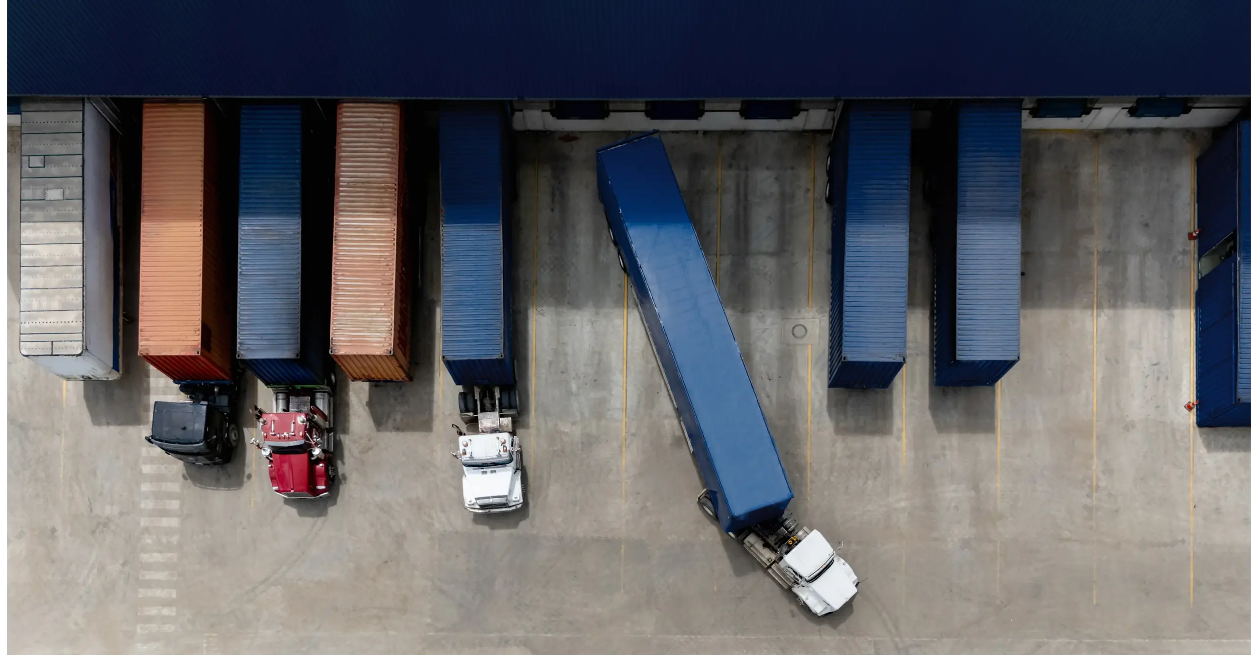 Aerial view of trucks and shipping containers in a loading area